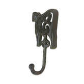 Decorative metal hook with intricate design on a white background