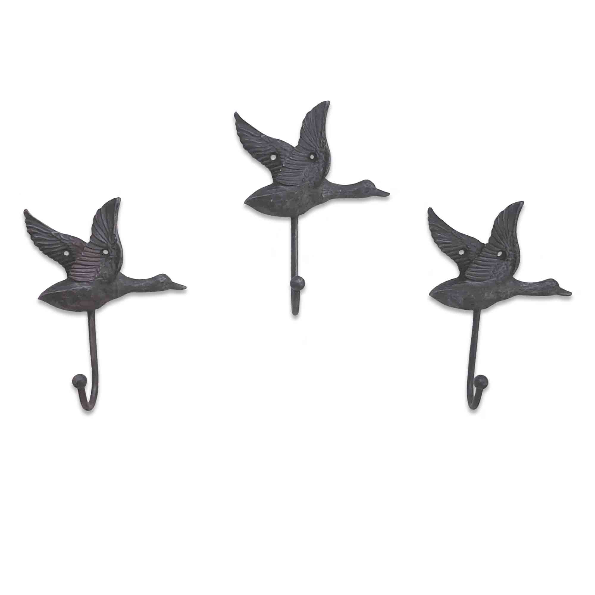 Three metal wall hooks shaped like birds on a white background