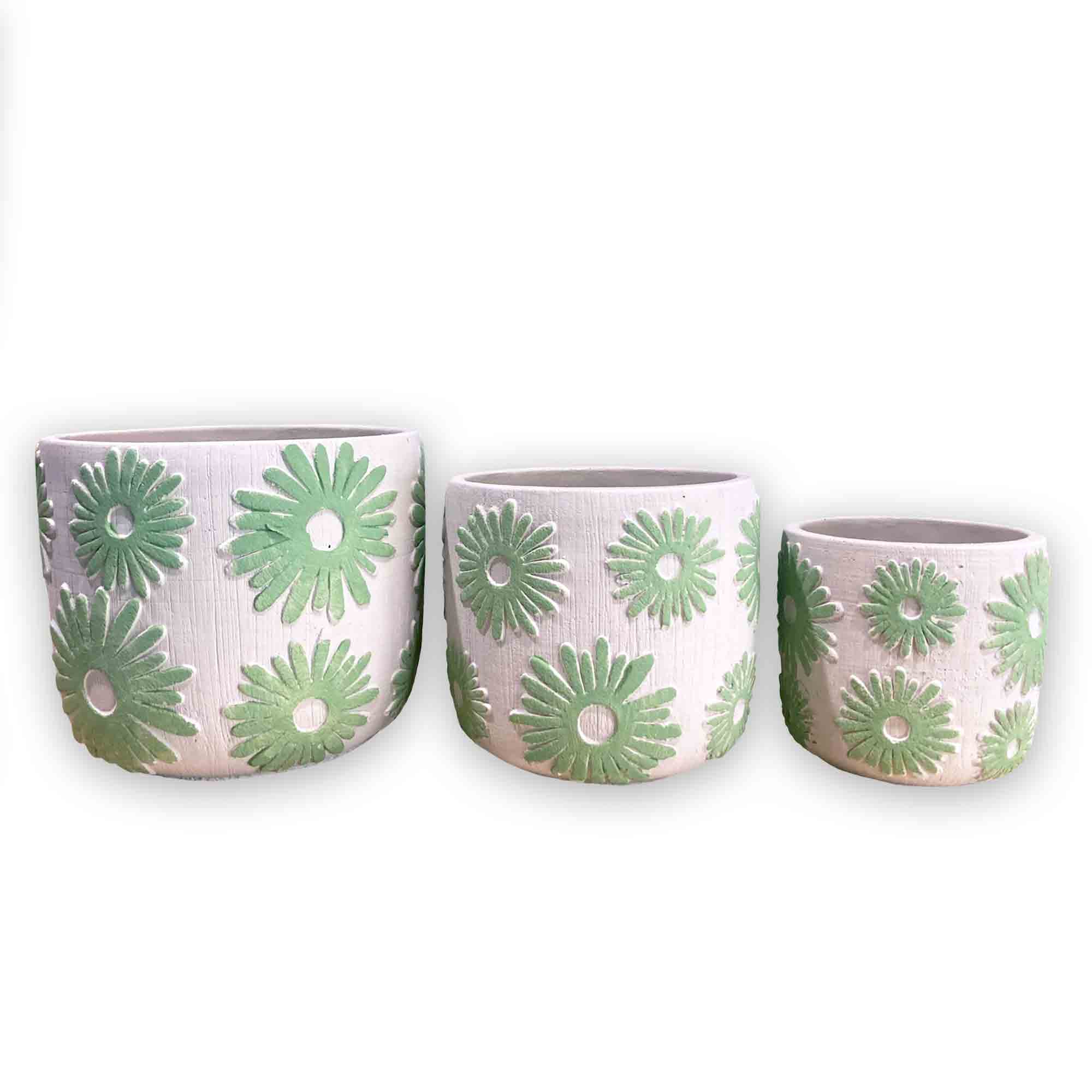 Three concrete planters with green floral daisy patterns on a white background