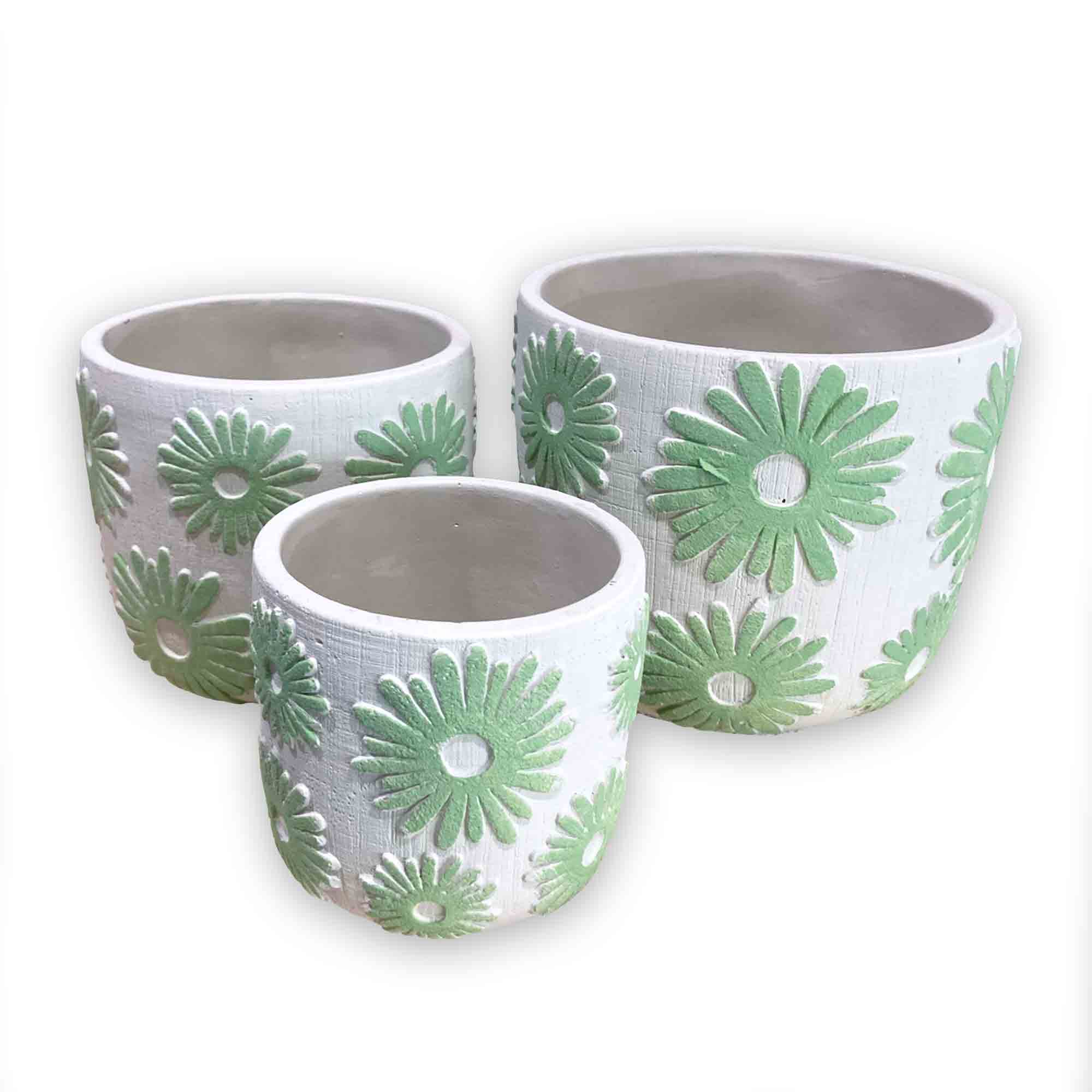 Three concrete pots with green floral daisy patterns on a white background
