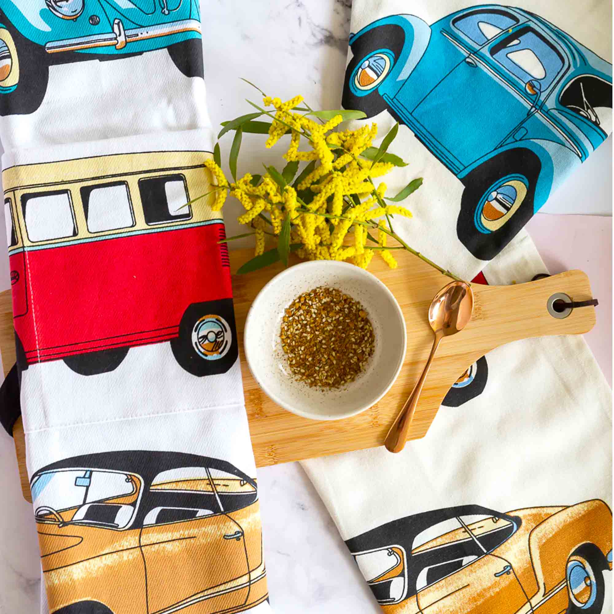 Aprons and tea towels with vintage car designs on a white background