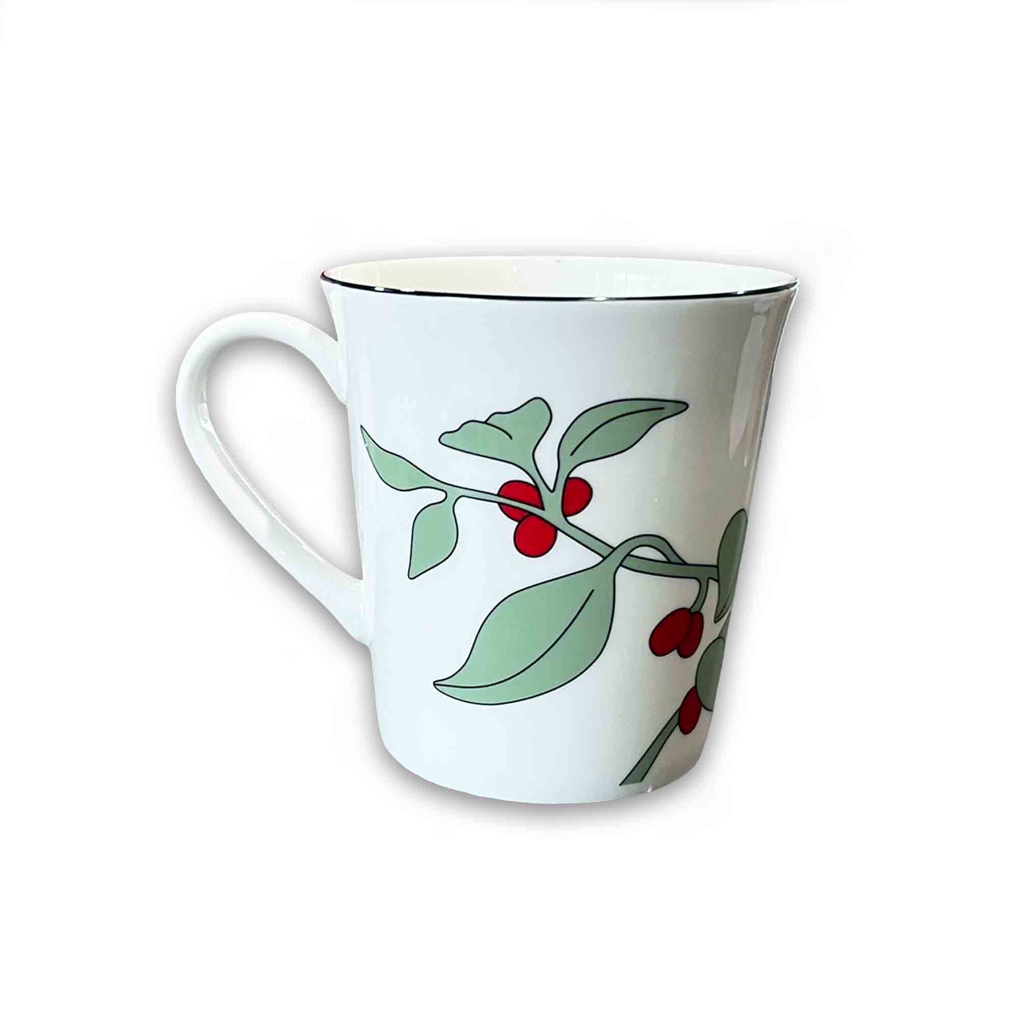 White mug with green leaves and red berries on a white background
