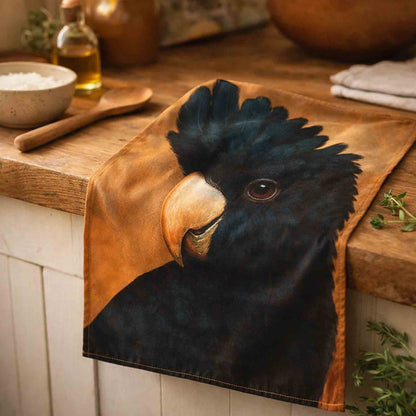 Kitchen tea towel with a Black Cockatoo design on a wooden surface