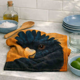 Black Cockatoo cotton tea towel styled on a coastal kitchen bench with natural folds, premium cotton texture