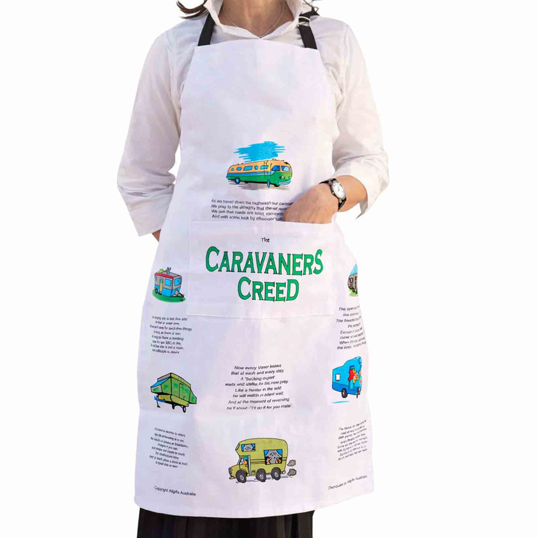Person wearing a white apron with caravan-themed designs and text.