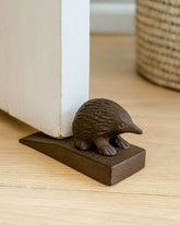 Australian Echidna metal wedge door stop holding open a door