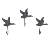 Three metal wall hooks shaped like birds on a white background