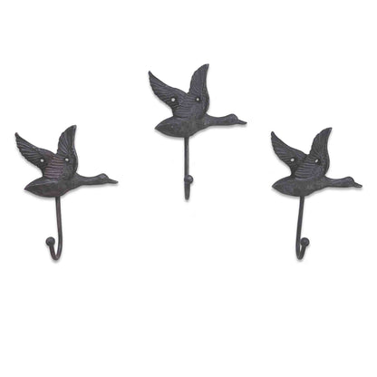 Three metal wall hooks shaped like birds on a white background