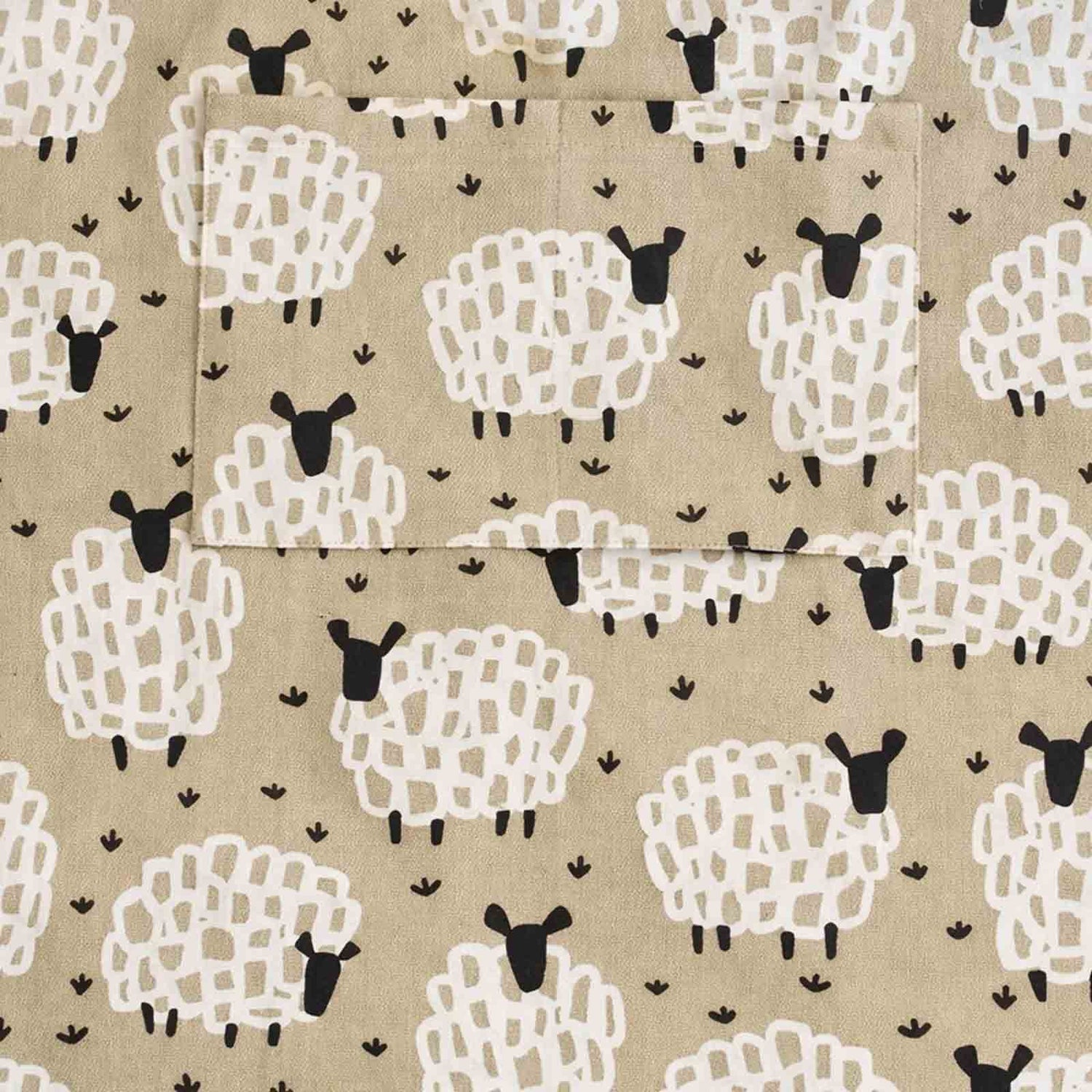 Close up of Grey Sheep apron showing pattern of white sheep with black faces on a greyish beige background
