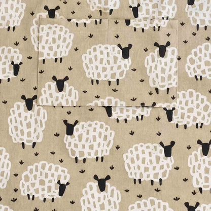 Close up of Grey Sheep apron showing pattern of white sheep with black faces on a greyish beige background