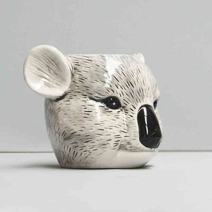 Ceramic koala head stationary/plant holder on a plain background