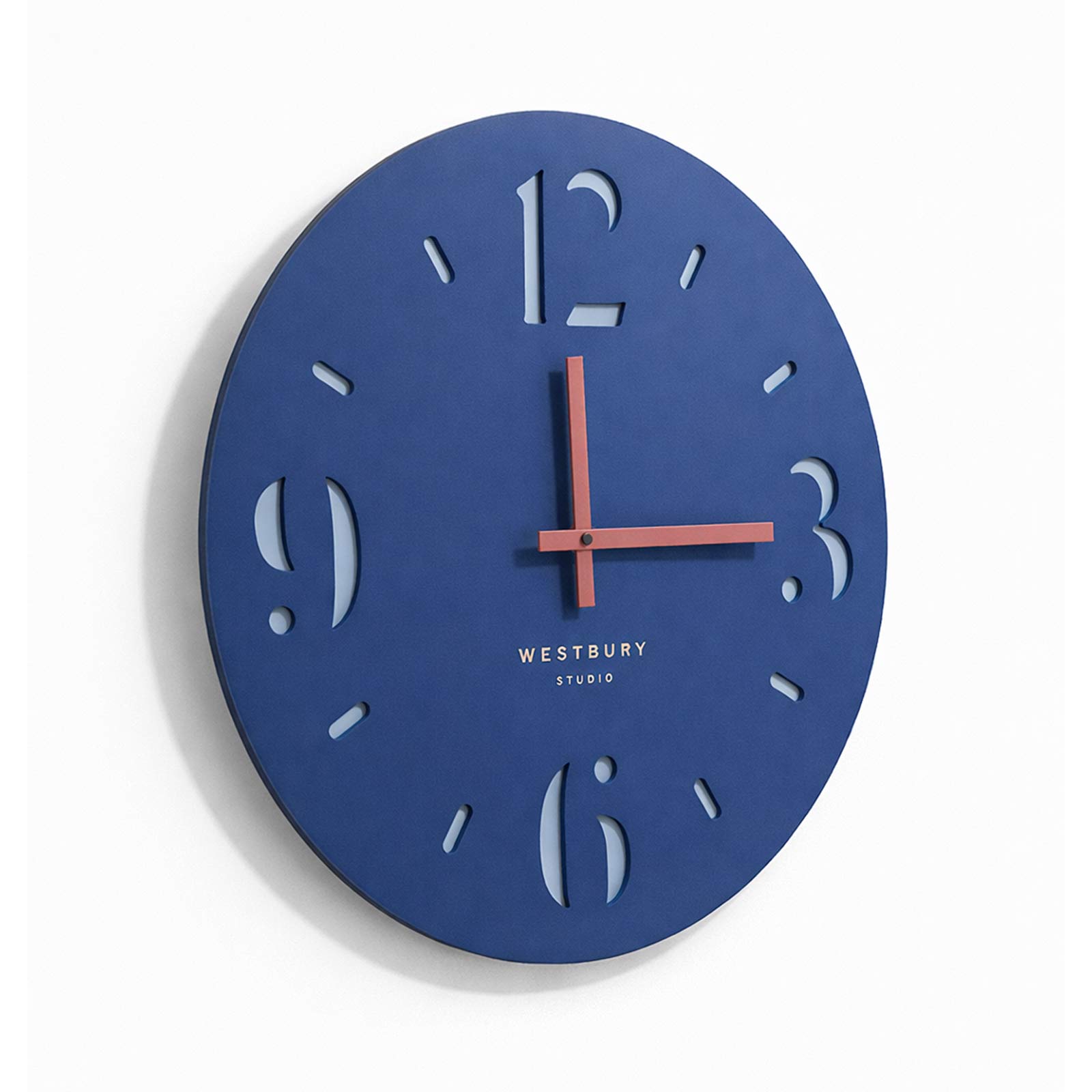 Blue wall clock with Westbury Studio branding on a white background