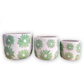 Three concrete planters of various sizes with mint green floral pattern