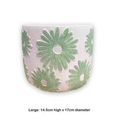Decorative pot with green floral patterns on a white background