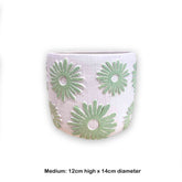 Concrete pot with green floral daisy pattern on a white background