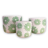 Set of three ceramic planters with green floral patterns on a white background
