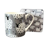 Mug and matching coaster with sheep pattern on a white background