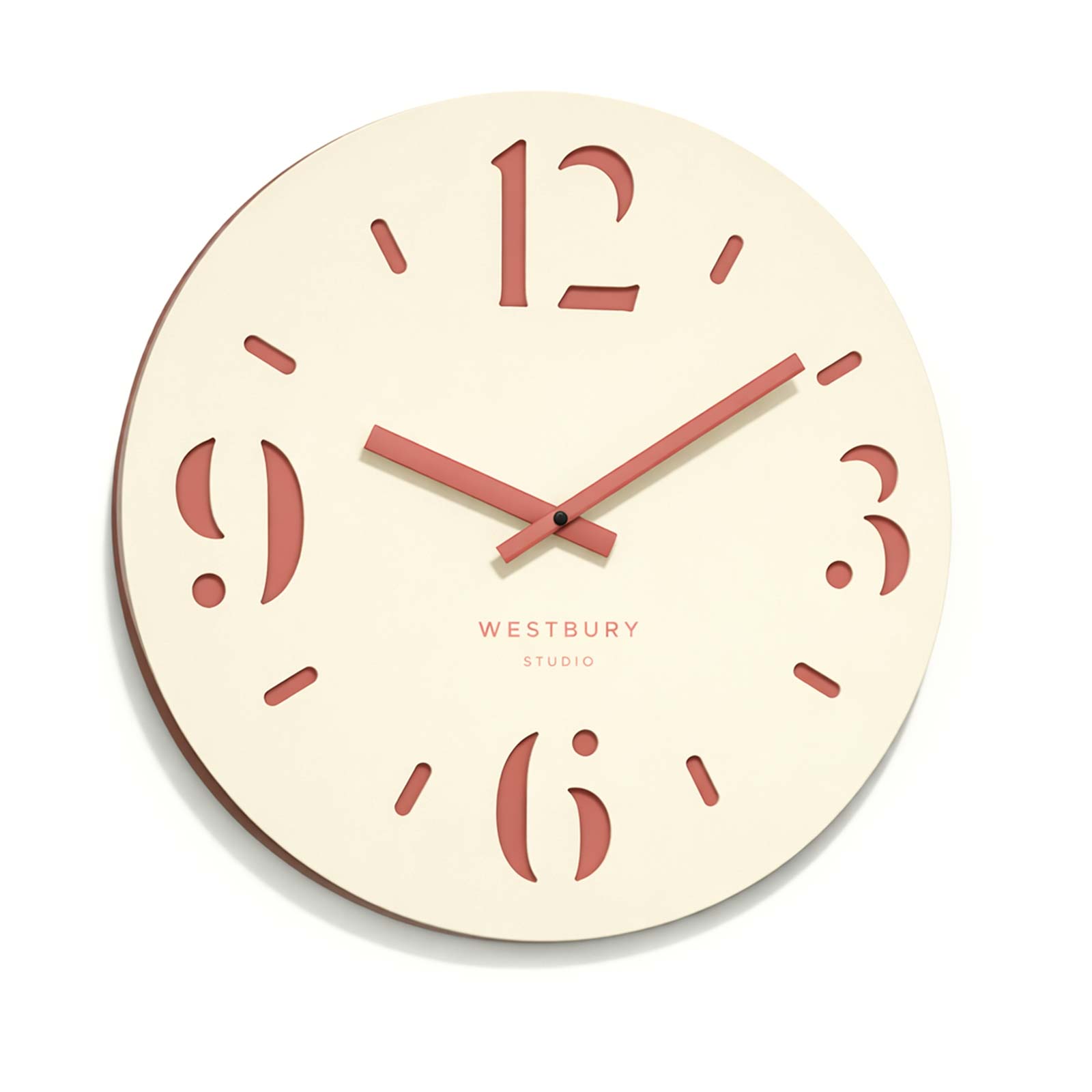 Cream coloured clock with cut out numerals on a dusty pink back.